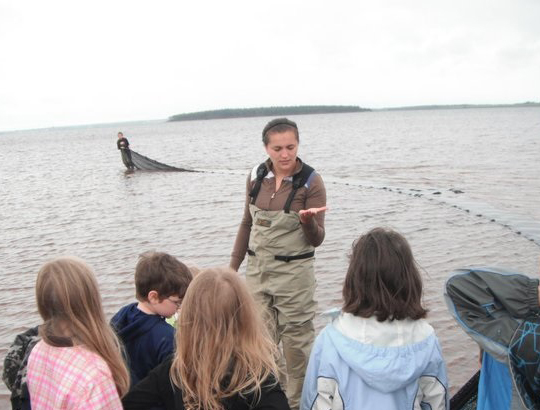 Expert teaching young children about water at the shore