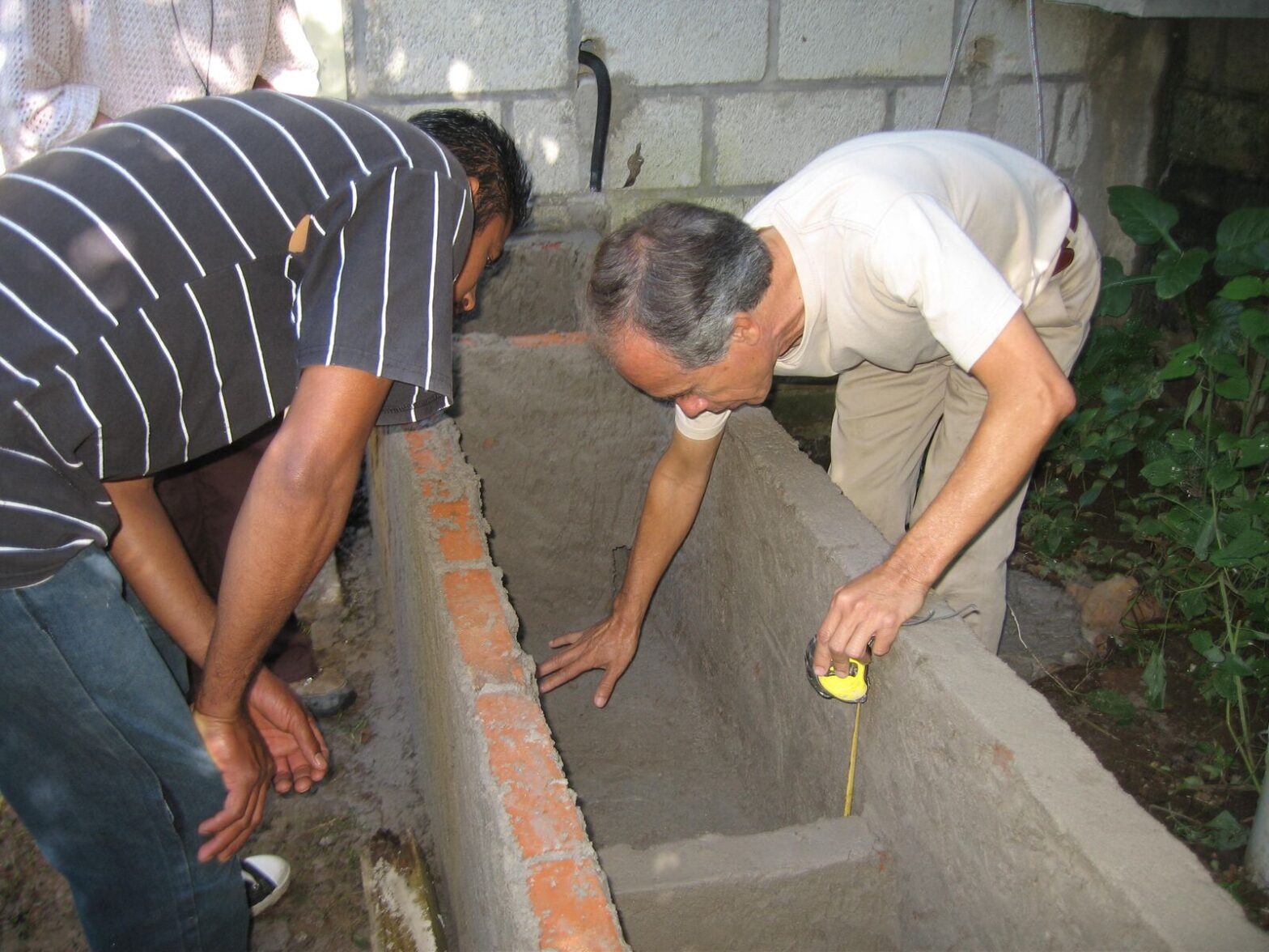Two men building a cistern