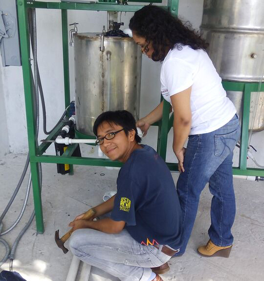 Two people building a biodiesel container