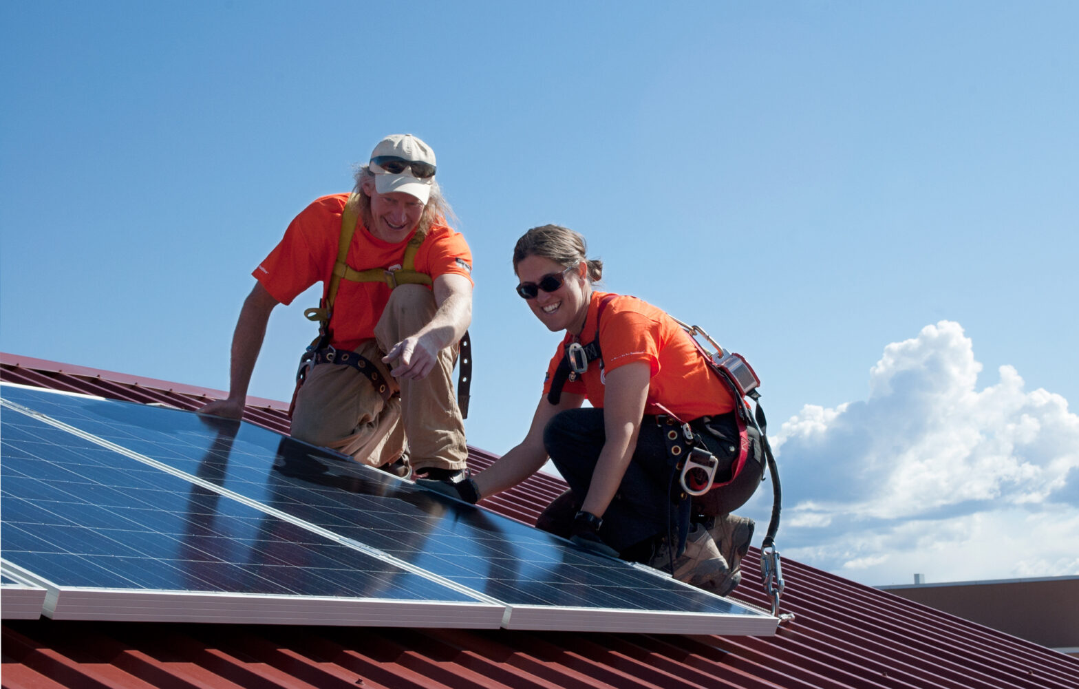 Two people installing solar panels